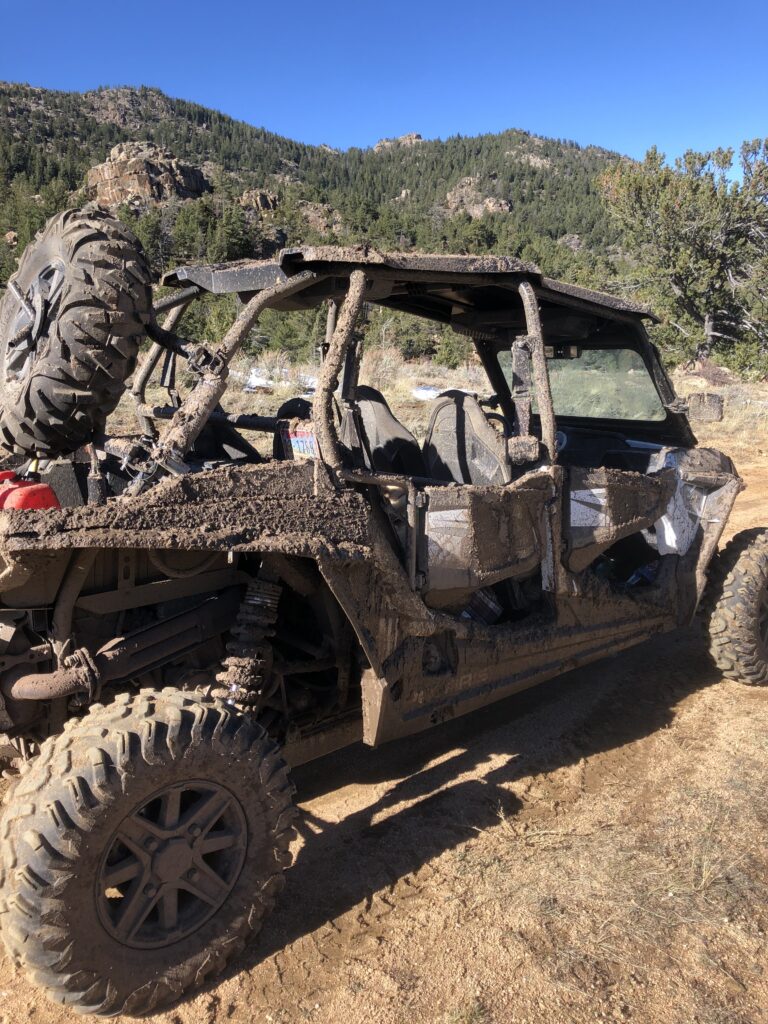 A muddy 4-seat side-by-side