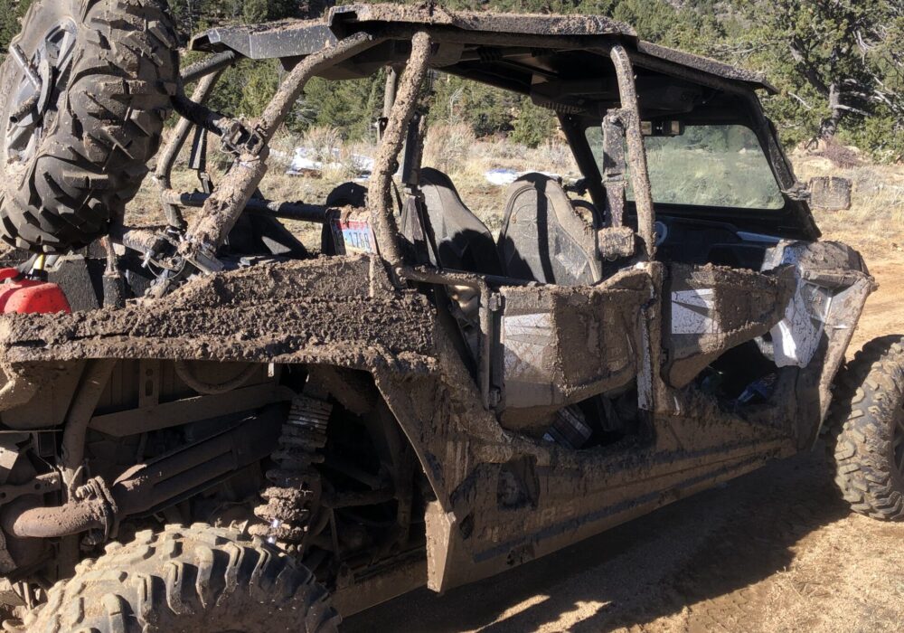 A muddy 4-seat side-by-side
